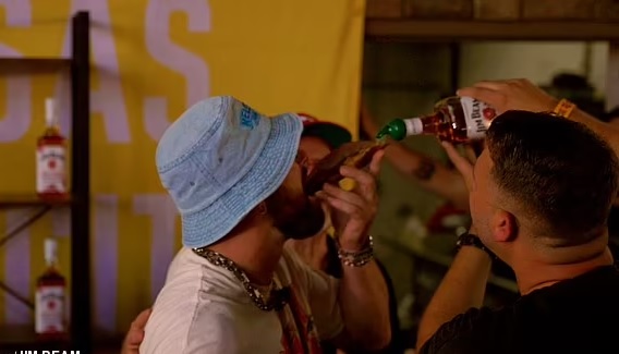 Travis Kelce downs a whiskey shot from a slice of BREAD and sings on stage with Patrick Mahomes as he lets loose at his music festival after leaving girlfriend Taylor Swift in Europe