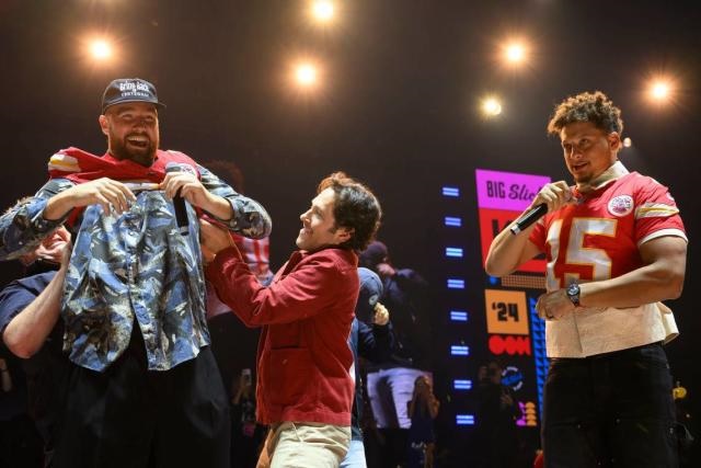 The brilliant moment when Travis Kelce did his bit for charity by modeling one of his own t-shirts on stage, at an event alongside teammate Patrick Mahomes.